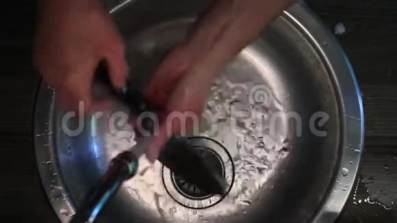 一个人在水槽的顶部洗刀视频的预览图
