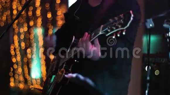 在夜店的深夜演出中音乐家在舞台上弹吉他的镜头被裁剪中弹视频的预览图