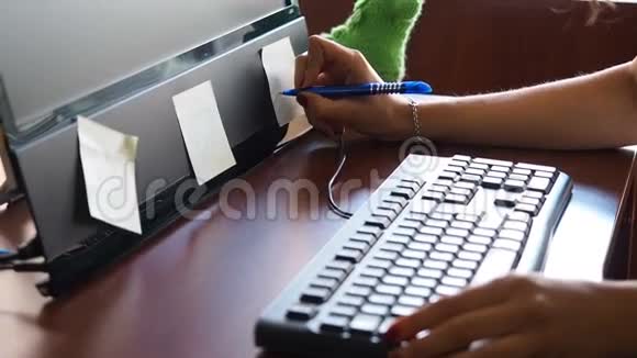 办公室里贴在显示器上的贴纸上写字的年轻女人视频的预览图