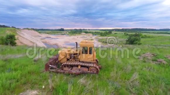 采石场矿井里的老黄色推土机夏季自然景观空中镜头视频的预览图