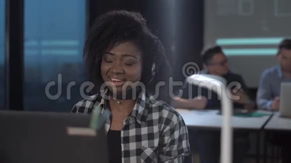 在呼叫中心工作的开朗的非洲女人视频的预览图