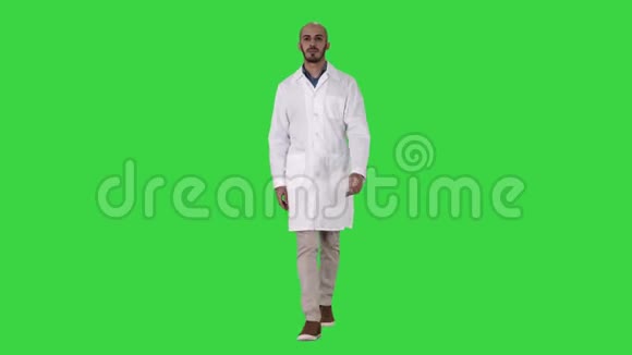 在绿色屏幕上行走的男性阿拉伯医生Chroma键视频的预览图