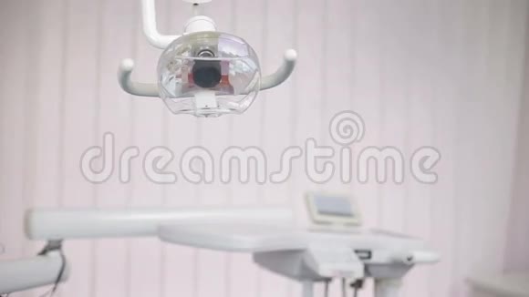 牙科灯架旁边的牙科椅和工具正在使用的牙医视频的预览图