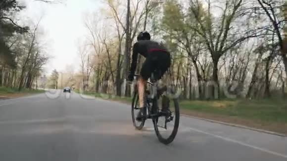 强壮自信的三项运动员在公园里骑自行车后面跟着射击铁人三项的概念慢动作视频的预览图