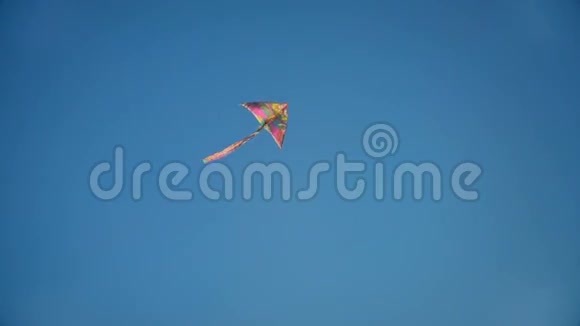 彩虹色风筝在背景上的蓝天飞翔视频的预览图