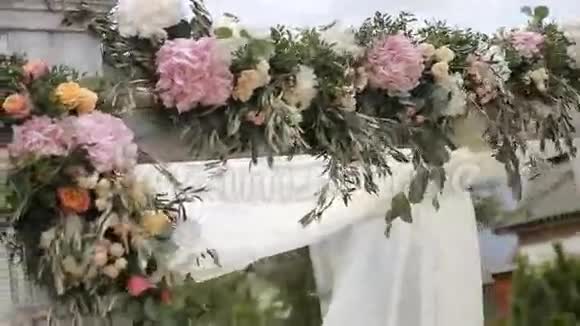 婚礼拱门在婚礼前用鲜花装饰在天空背景下视频的预览图