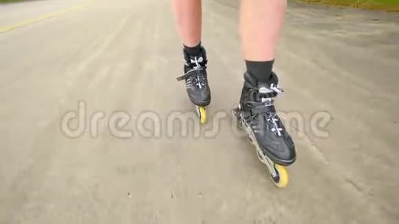 在松林的路上滑着滑溜在炎热的夏天曼斯腿在沥青上轮滑快速洗牌视频的预览图