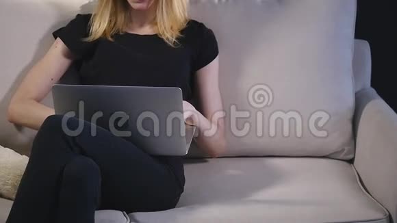 沙发上有笔记本电脑的女孩黑色背景视频的预览图
