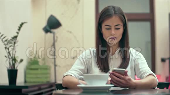 使用智能手机应用于慢动作咖啡屋的妇女视频的预览图