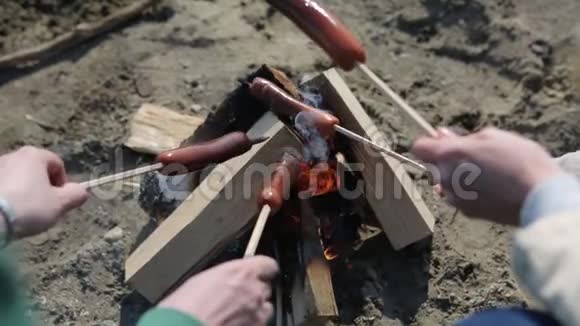 在露天篝火上制作和烹饪热狗香肠视频的预览图