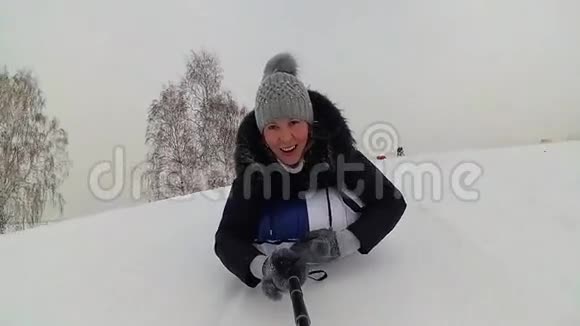 快乐的女孩骑着雪管在雪道上微笑慢动作冬天的雪景户外运动视频的预览图