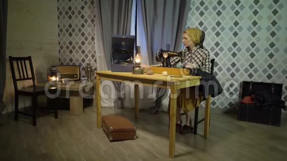 复古女裁缝用旧手工缝纫机缝制布在家工作或在夜间工作的妇女视频的预览图