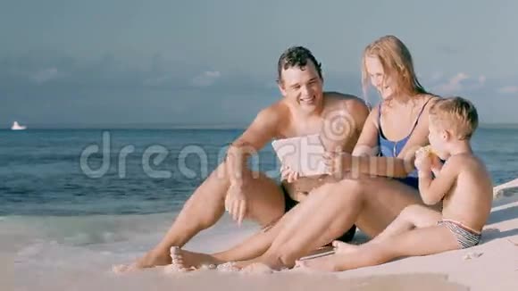 三口之家幸福的坐在海边视频的预览图