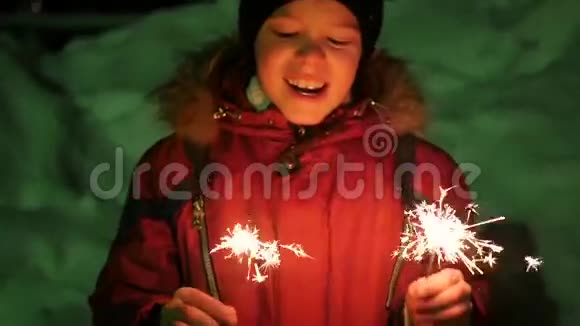 冬天这个孩子在户外拿着火花慢动作视频的预览图