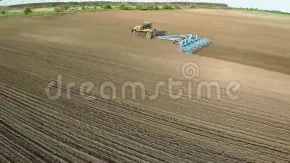 一辆现代拖拉机耕旱地准备播种土地的高清空中镜头视频的预览图
