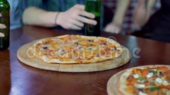 朋友们在餐馆里等披萨的时候喝啤酒和聊天慢动作视频的预览图