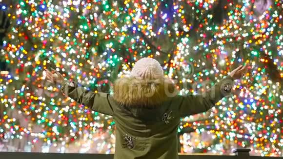 纽约洛克菲勒圣诞树背景下的快乐女孩视频的预览图