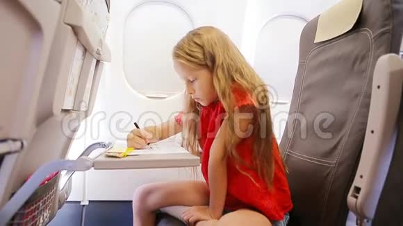 可爱的小女孩坐飞机坐飞机窗孩子用彩色铅笔画图片视频的预览图