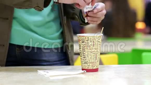 女人的特写镜头将红糖放入茶或咖啡杯中视频的预览图