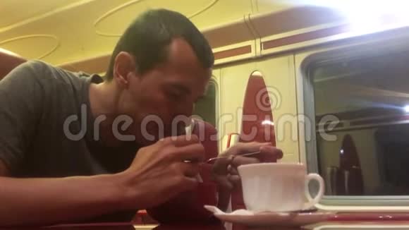 男人晚上在火车餐厅吃汤铁路猫喝咖啡男子生活方式在火车概念之旅视频的预览图