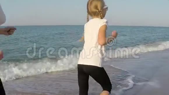 妈妈和女儿在海滩上奔跑视频的预览图