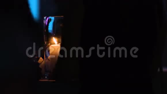 两个人正坐在玻璃杯里摆着一支白色蜡烛的桌子旁客人们正在准备一杯鸡尾酒视频的预览图