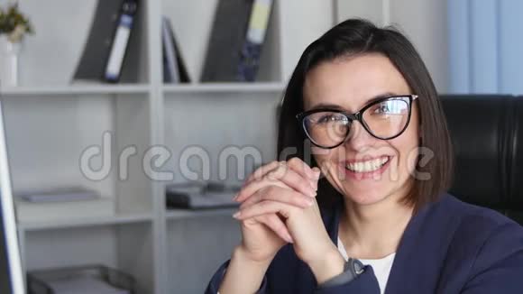 成功的女商人在办公室工作看着镜头微笑视频的预览图