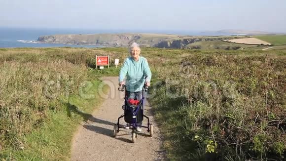有活力的老年退休金领取者走向相机与三轮无轨电车移动援助海岸路径视频的预览图