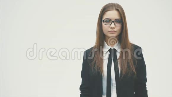 年轻的商业女孩站在白色的背景上穿着黑色的夹克视频的预览图