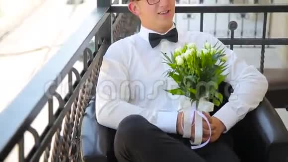 年轻人正拿着结婚花束坐在阳台上视频的预览图
