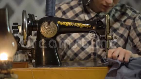复古女裁缝用旧手工缝纫机缝制布女人晚上在家工作或在工厂工作视频的预览图
