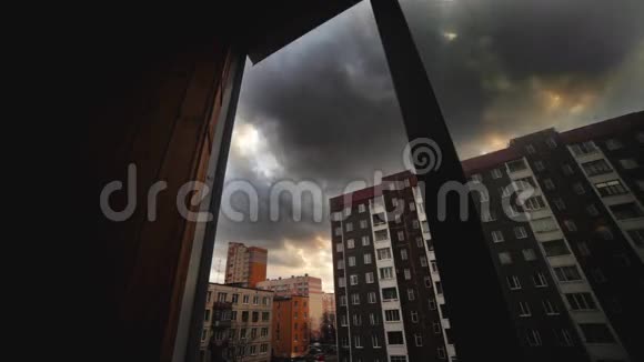 白天在城市经过从建筑物的窗户看灰色的云时光流逝视频的预览图