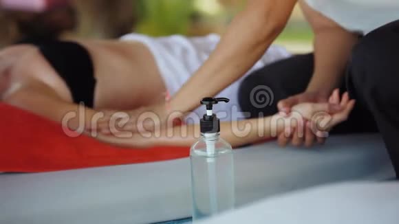 年轻女子躺在热带海滩上放松的水疗沙龙里关闭按摩师做手油按摩视频的预览图