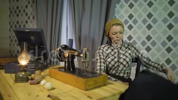 漂亮的复古女裁缝用旧的手工缝纫机缝制布在家工作或在车间工作的妇女视频的预览图