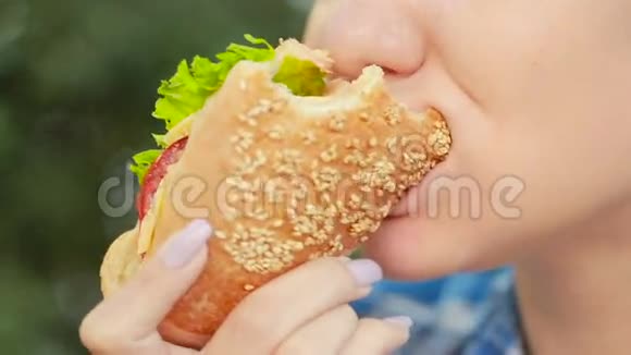 年轻女孩吃三明治快餐概念三明治咬人视频的预览图