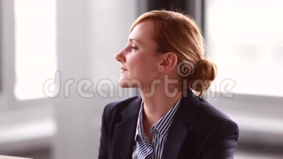 年轻的女商人在公司演讲时听着点头视频的预览图
