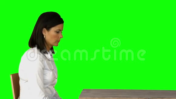 愤怒的女商人坐在绿色屏幕上的椅子上视频的预览图
