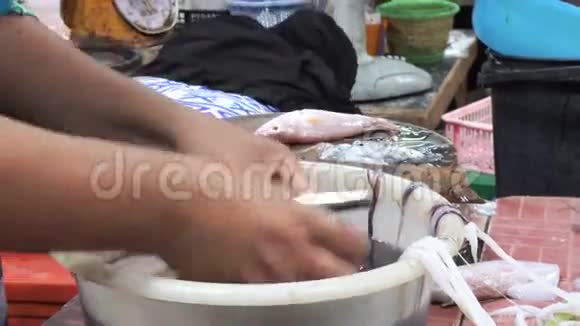 亚洲女性手在海鲜市场剥鱿鱼视频的预览图