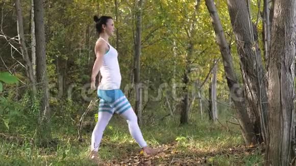 在户外树林里做瑜伽的年轻女人健康的生活方式视频的预览图