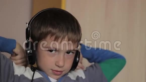 坐在桌边听音乐的男孩视频的预览图