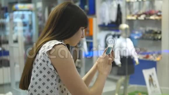 年轻女子在购物中心玩口袋妖怪在室内玩使用智能手机女孩玩流行的智能手机游戏视频的预览图