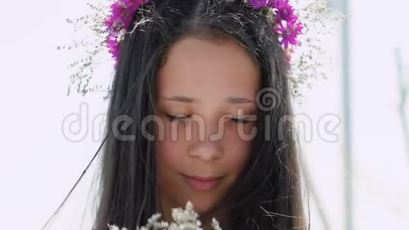 快乐的年轻女孩欣赏着鲜花和微笑慢慢地视频的预览图