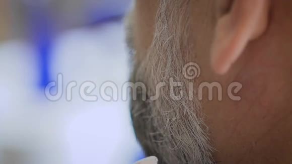 理发师给他的客户修胡子古色古香的沙龙侍奉大师白发苍苍的男人而且在这个年纪视频的预览图