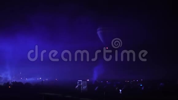 夜辉热气球社区节飞行员准备拿缓慢移动的热气球火热在里面视频的预览图