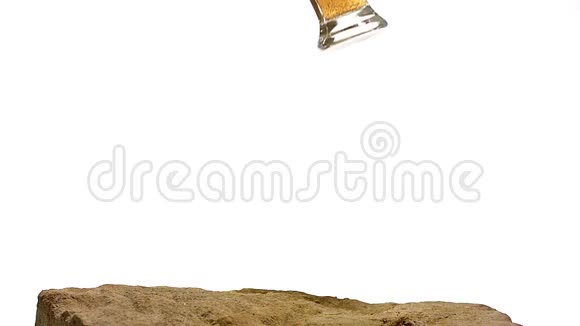 一杯啤酒在白色背景下洒在石头上视频的预览图