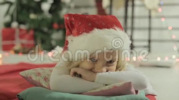 可爱的金发小女孩躺在枕头上视频的预览图