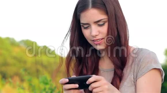 公园里的年轻女子在平板电脑上发短信视频的预览图