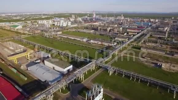 一个巨大的炼油厂有管道和蒸馏的综合体在一个绿色的领域空中景观视频的预览图
