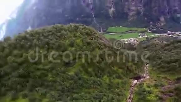 跳伞员跳伞降落在被绿色森林覆盖的山上极限运动视频的预览图