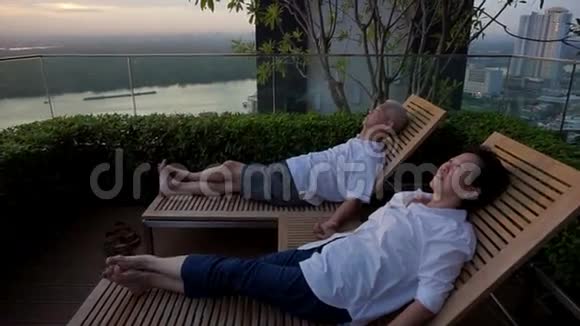 视频退休的亚洲夫妇坐在屋顶一起看日出抽象人生目标视频的预览图